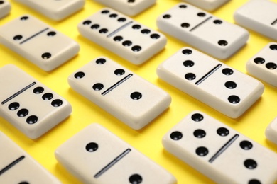 Classic domino tiles on yellow background, closeup