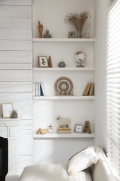 Many shelves with different decor near sofa in room. Interior design