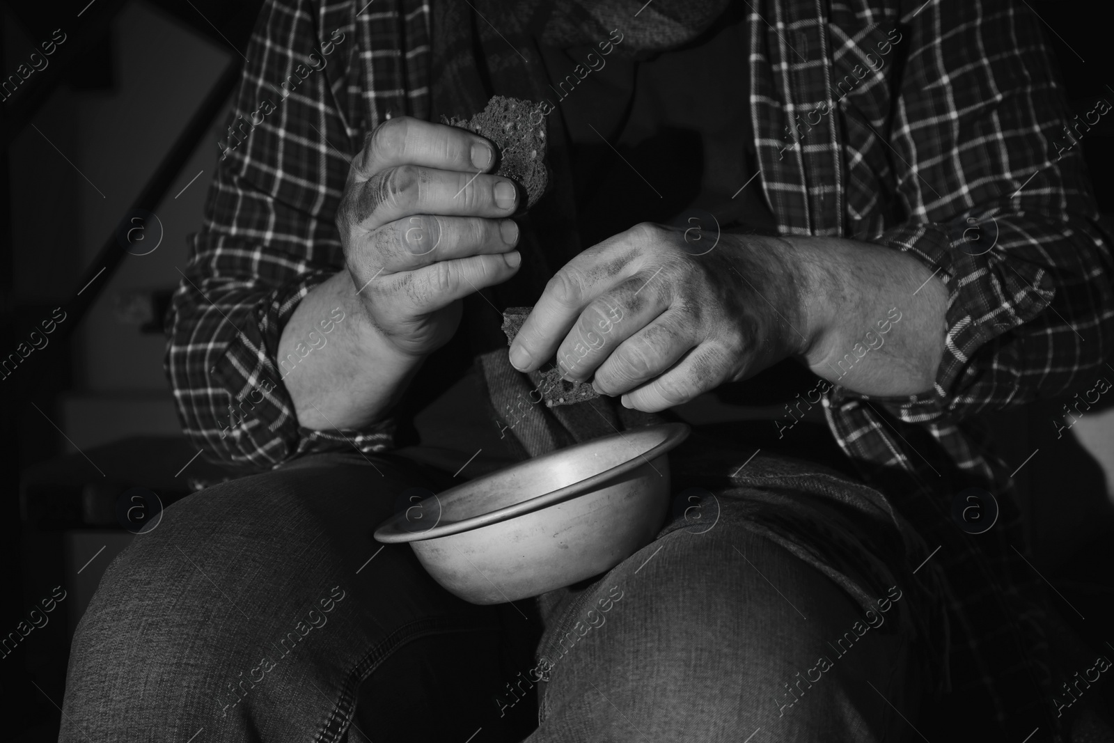 Photo of Poor senior man with bowl and bread, closeup. Black and white effect