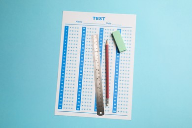 Answer sheet, pencil and ruler on light blue background, top view. Student passing exam