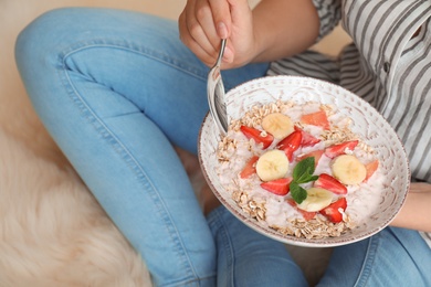 Photo of Woman eating delicious oatmeal with fruits at home. Healthy diet