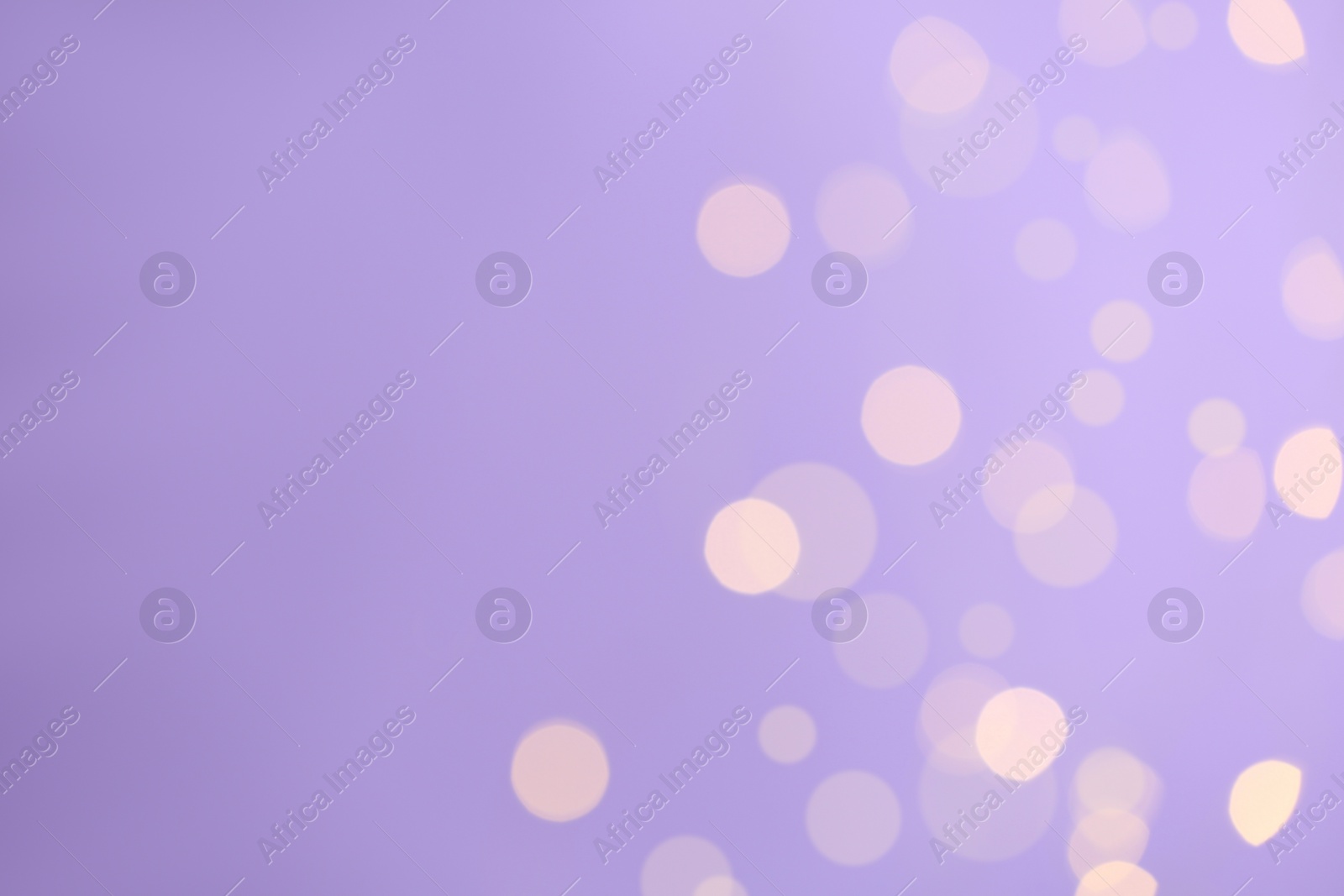 Photo of Blurred view of festive lights on violet background, space for text. Bokeh effect