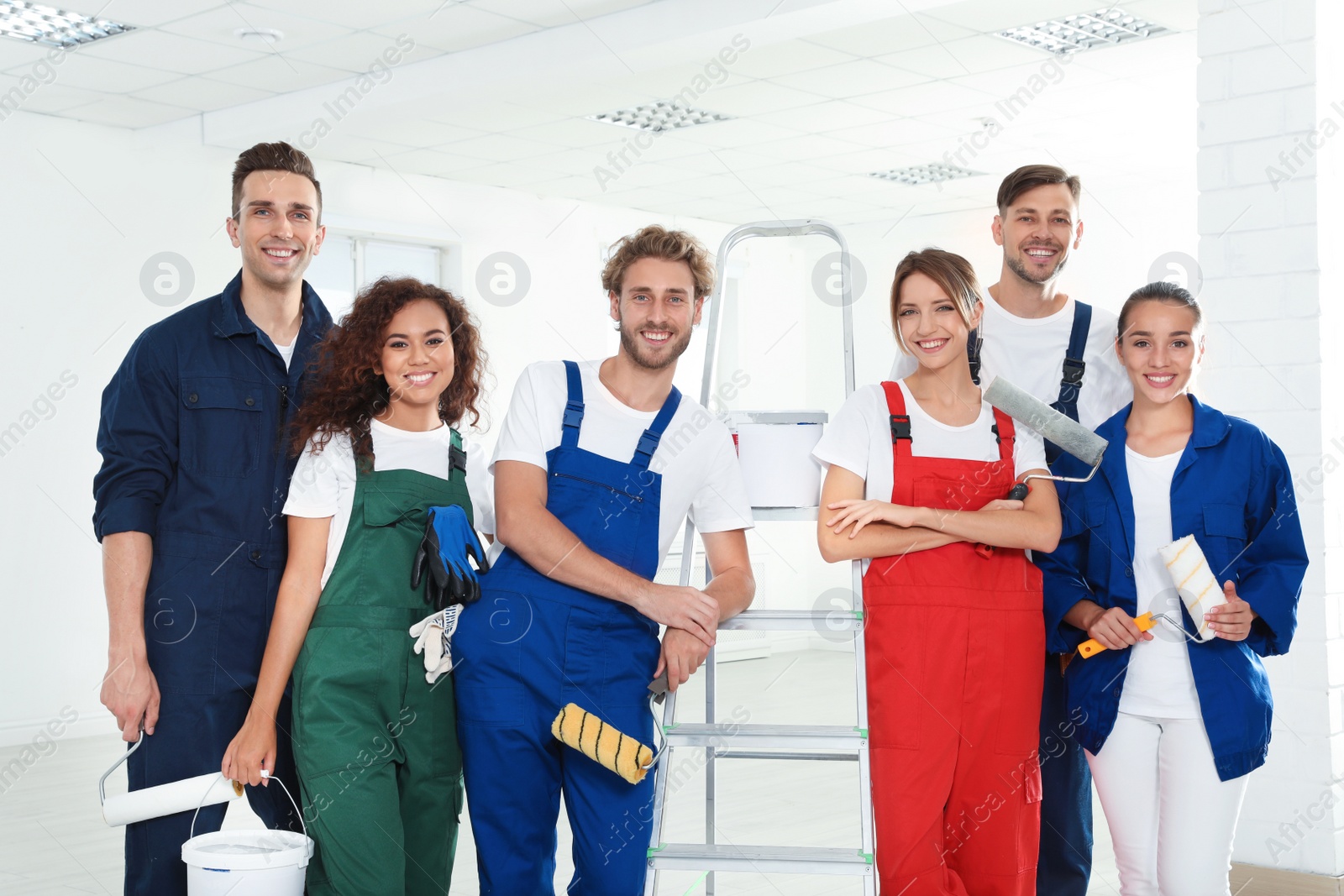 Photo of Team of professional painters with tools indoors