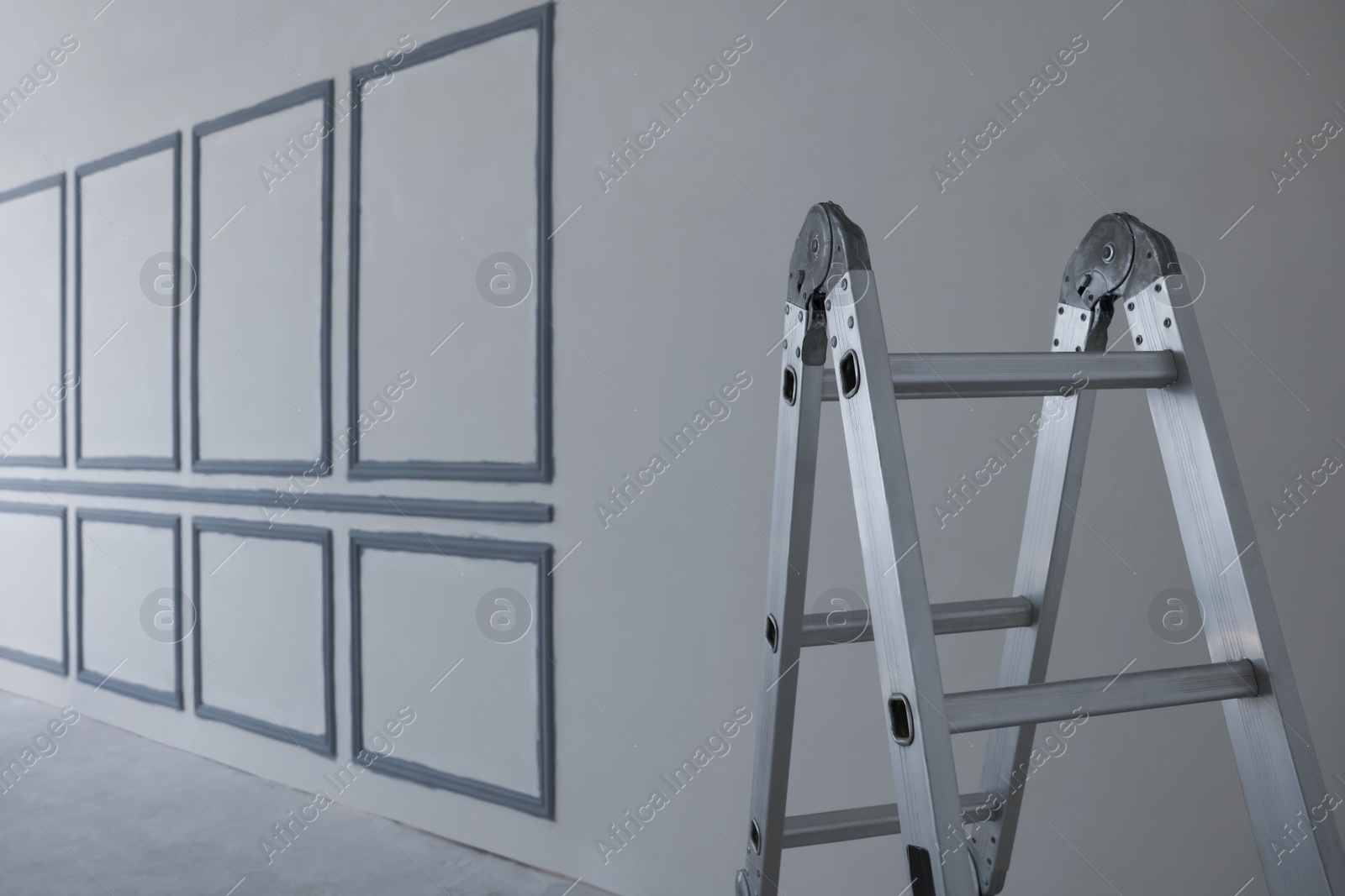 Photo of Metal ladder near fresh painted walls indoors