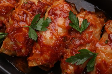 Photo of Delicious stuffed cabbage rolls cooked with tomato sauce in baking dish, top view