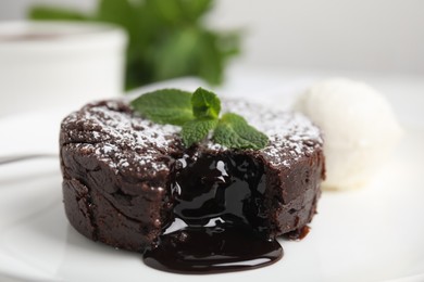 Photo of Delicious fresh fondant with hot chocolate, mint and ice cream served on plate, closeup