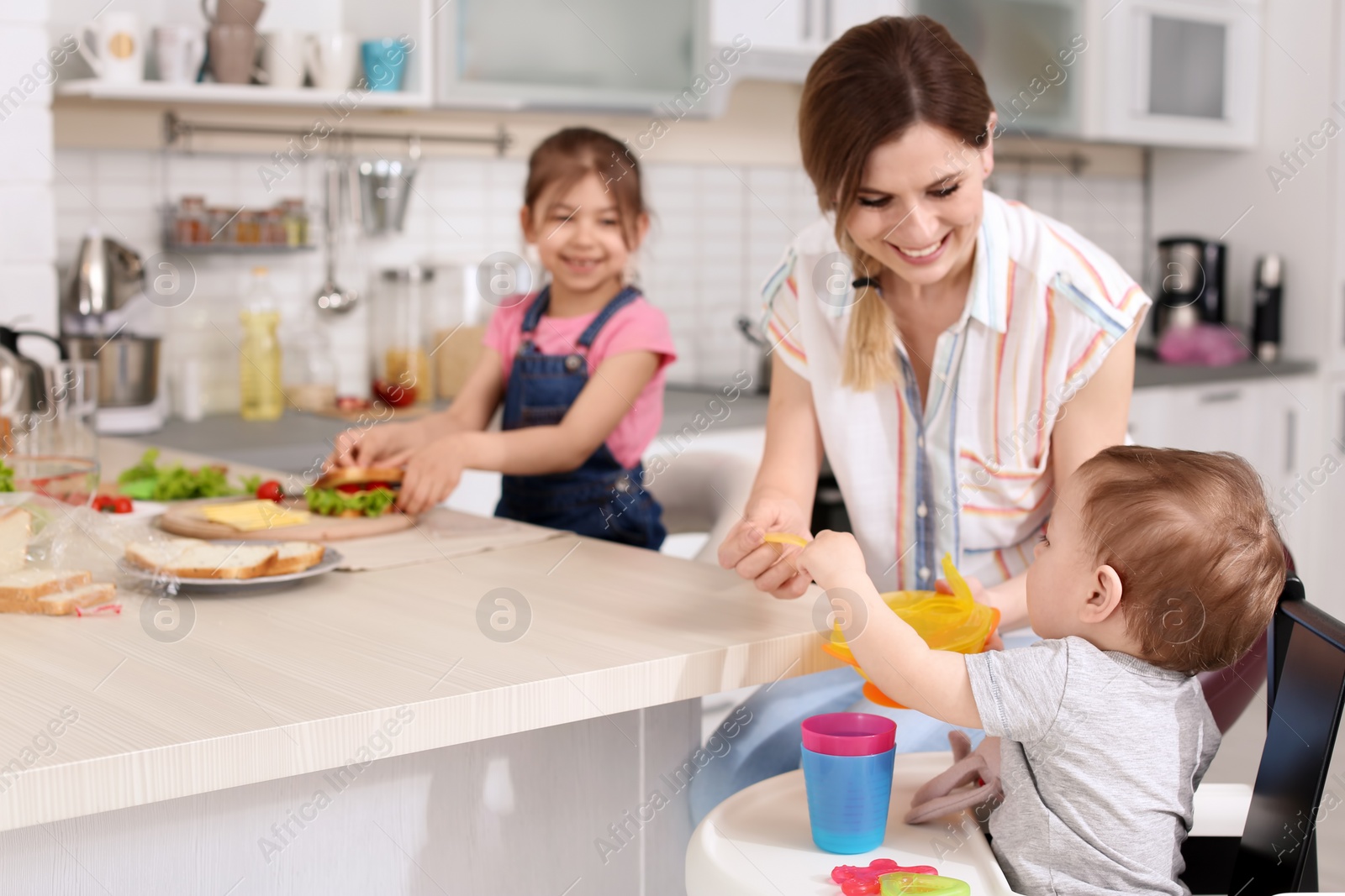 Photo of Housewife preparing dinner with her children on kitchen