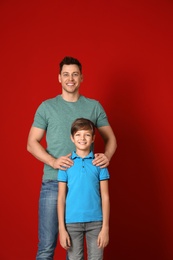 Portrait of dad and his son on color background