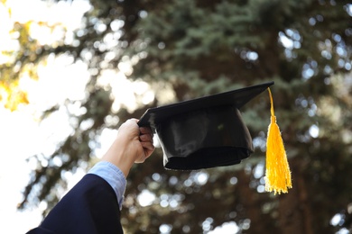 Student with graduation hat outdoors on sunny day, closeup