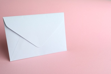 Photo of White paper envelope on pink background. Space for text