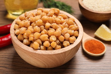 Photo of Delicious chickpeas and different products on wooden table. Hummus ingredients