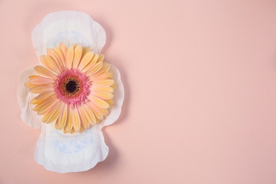 Photo of Flat lay composition with menstrual pad and flower on color background. Gynecological checkup