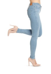 Photo of Woman wearing stylish light blue jeans and high heels shoes on white background, closeup