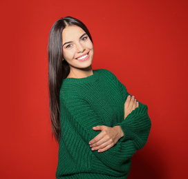 Image of Pretty woman wearing warm sweater on red background 