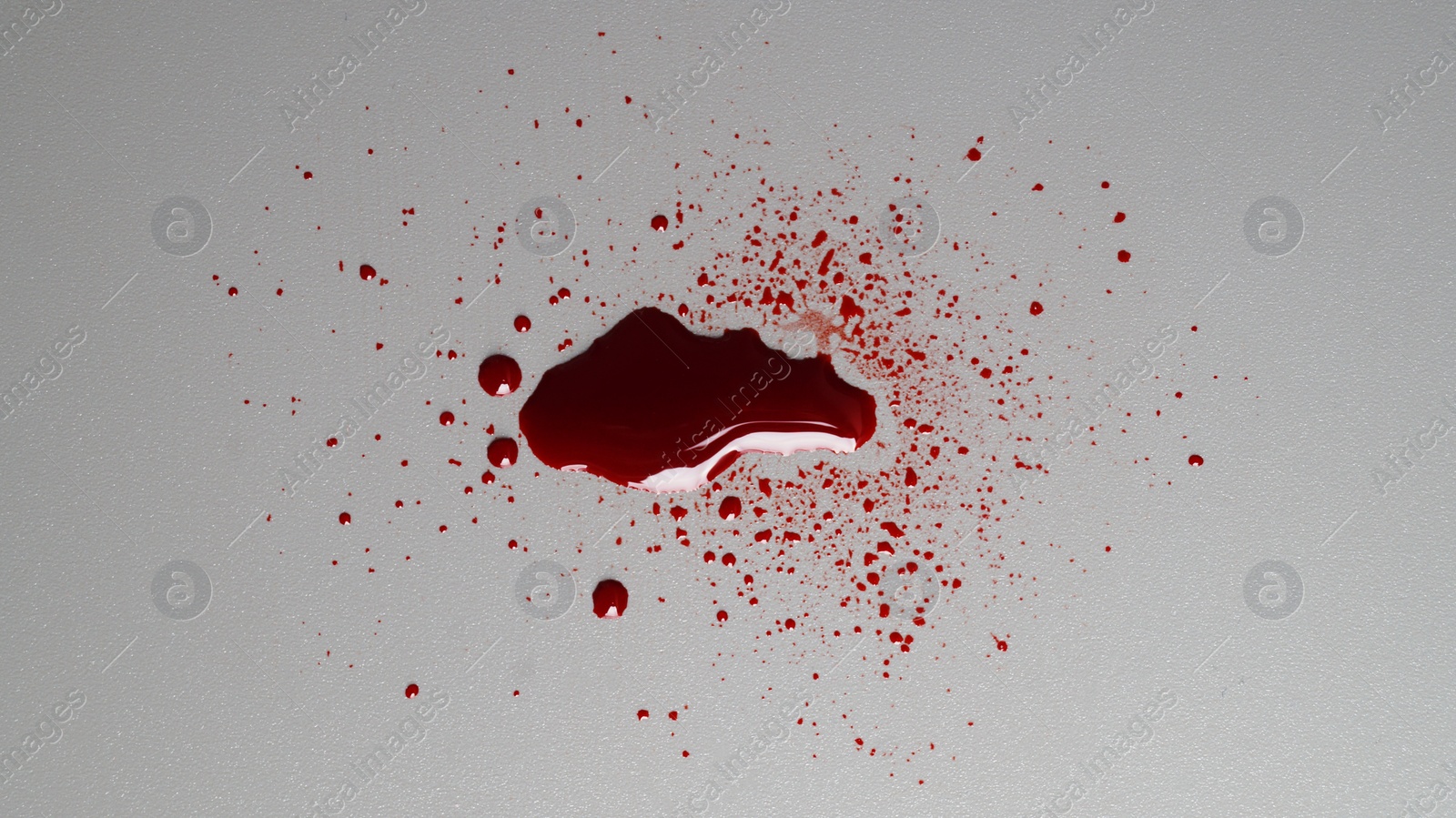 Photo of Stain and splashes of blood on grey background, top view