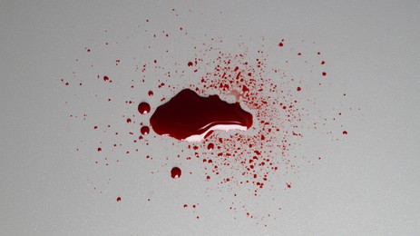 Photo of Stain and splashes of blood on grey background, top view