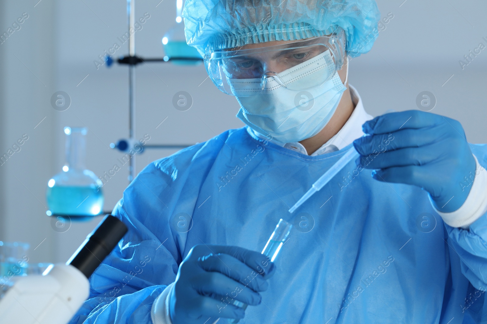 Photo of Scientist dripping sample into test tube in laboratory. Medical research