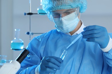 Scientist dripping sample into test tube in laboratory. Medical research