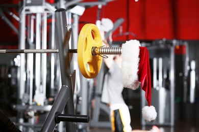 Photo of Santa Claus hat on barbell in gym