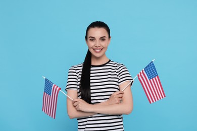 Photo of 4th of July - Independence Day of USA. Happy woman with American flags on light blue background
