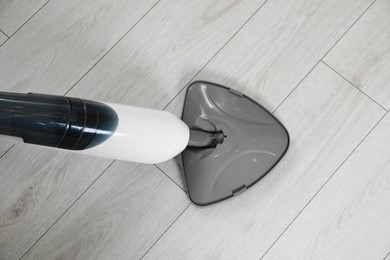 Photo of Cleaning floor with steam mop at home, top view