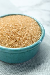 Photo of Brown sugar in bowl on table, closeup