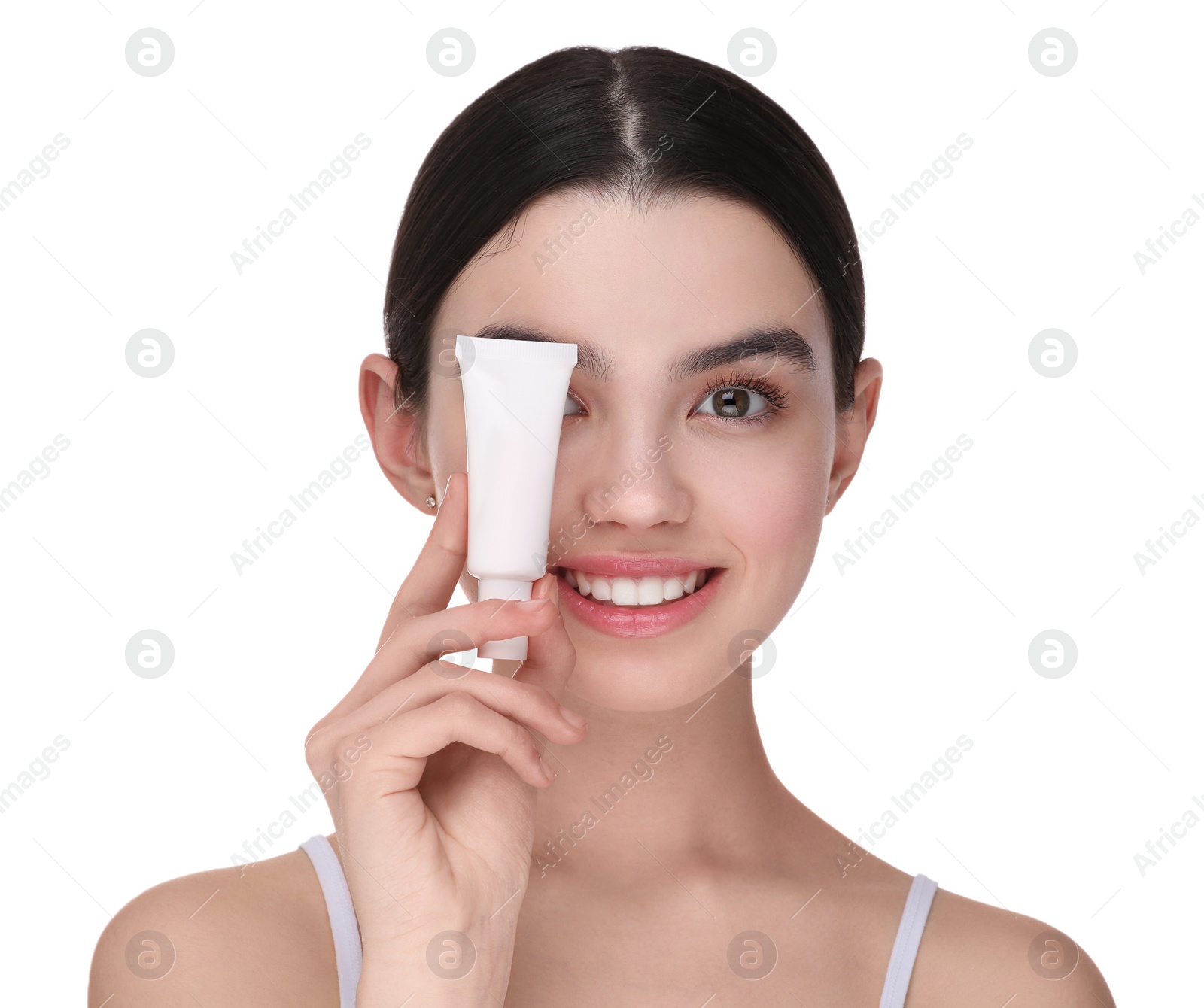 Photo of Teenage girl holding tube of foundation on white background