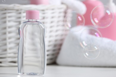 Bottle of baby cosmetic product on white table, space for text