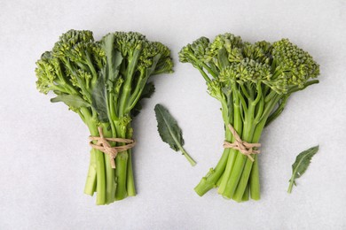 Fresh raw broccolini on white table, flat lay. Healthy food