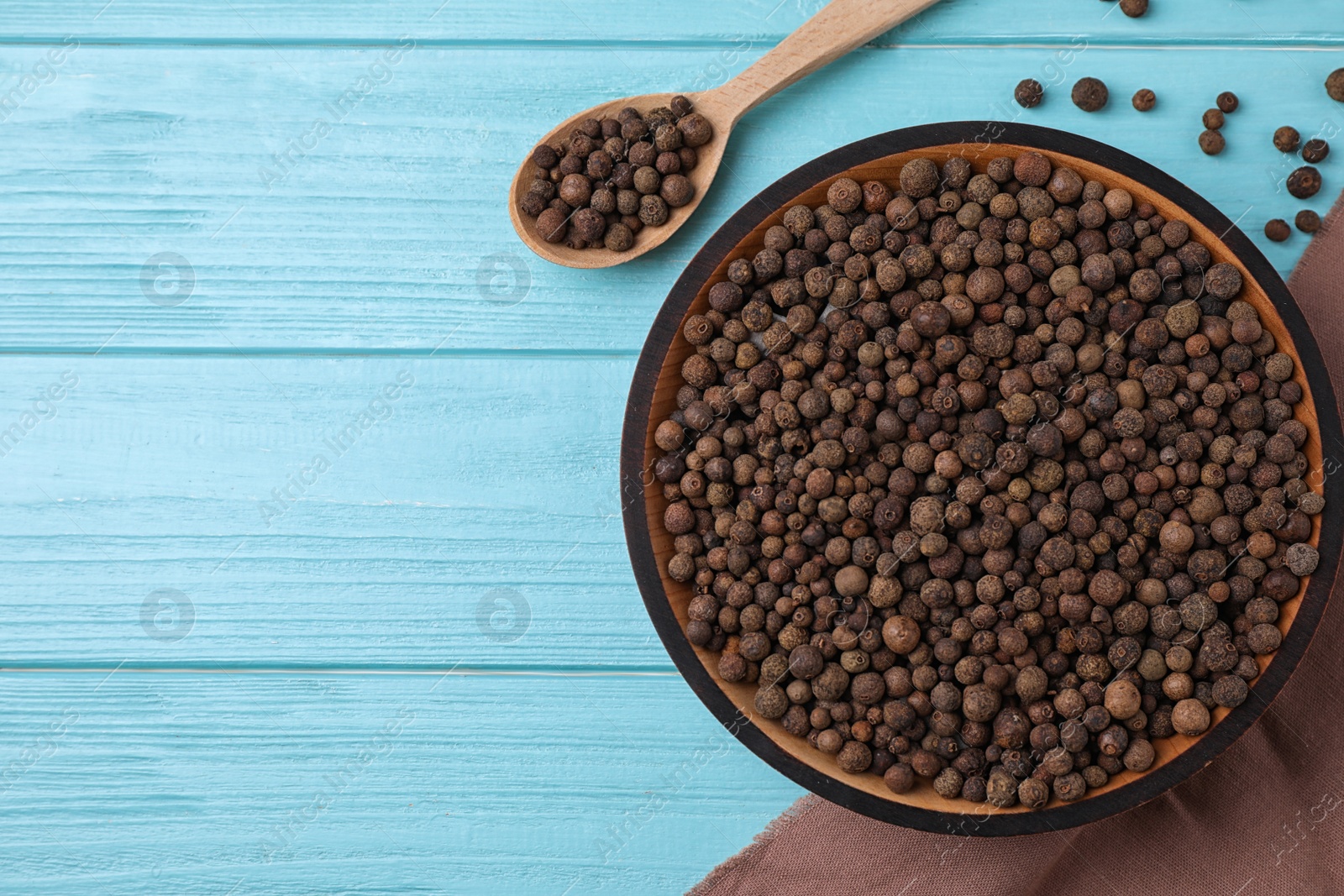Photo of Peppercorns on light blue wooden table, flat lay. Space for text