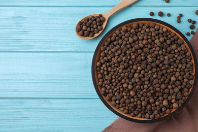 Photo of Peppercorns on light blue wooden table, flat lay. Space for text