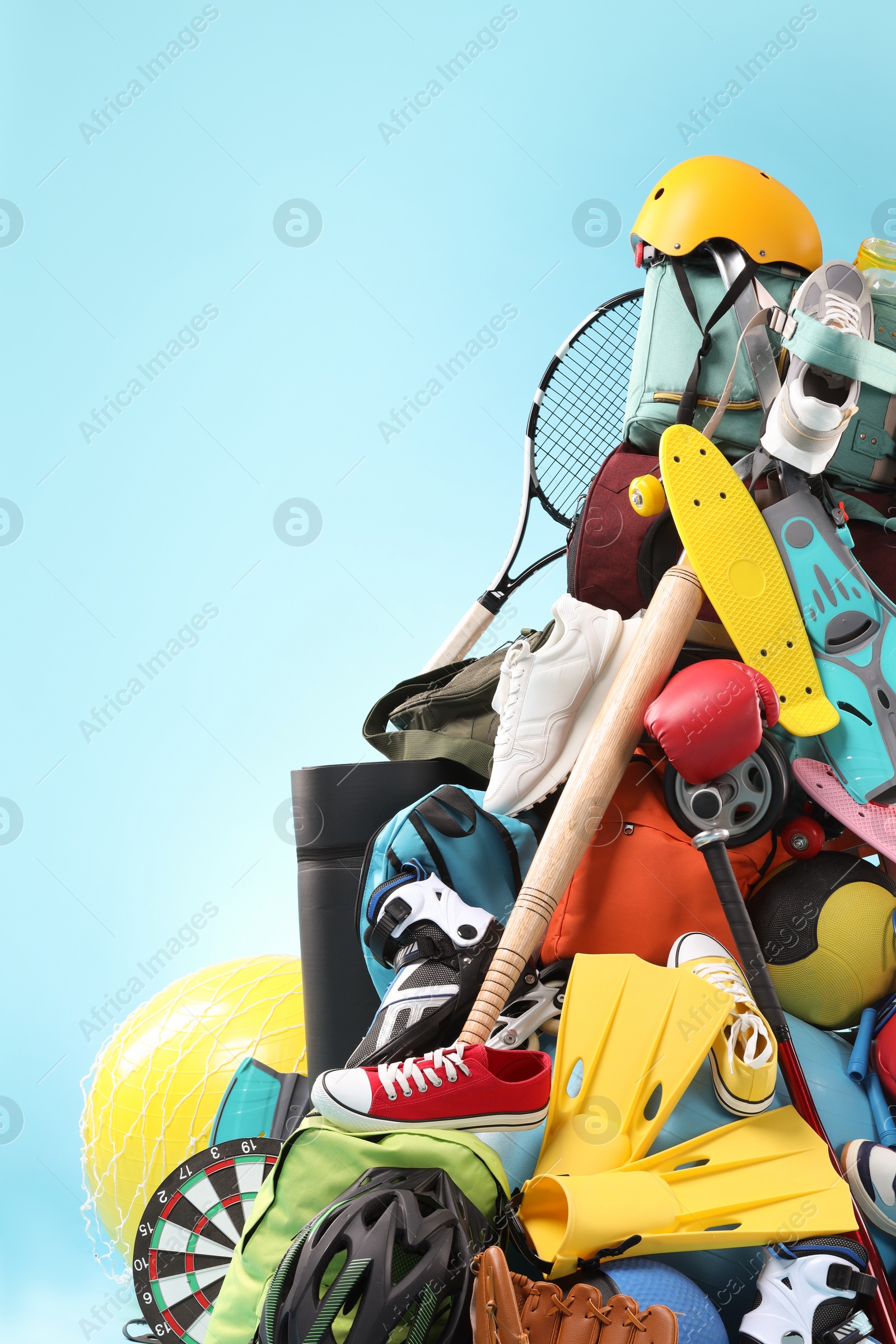 Photo of Many different sports equipment on light blue background
