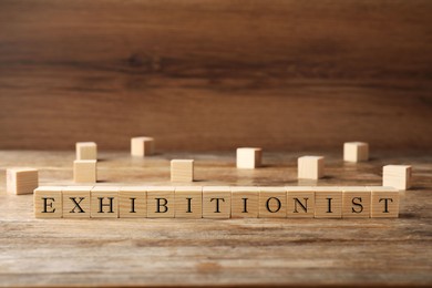 Photo of Word EXHIBITIONIST made with wooden cubes on table