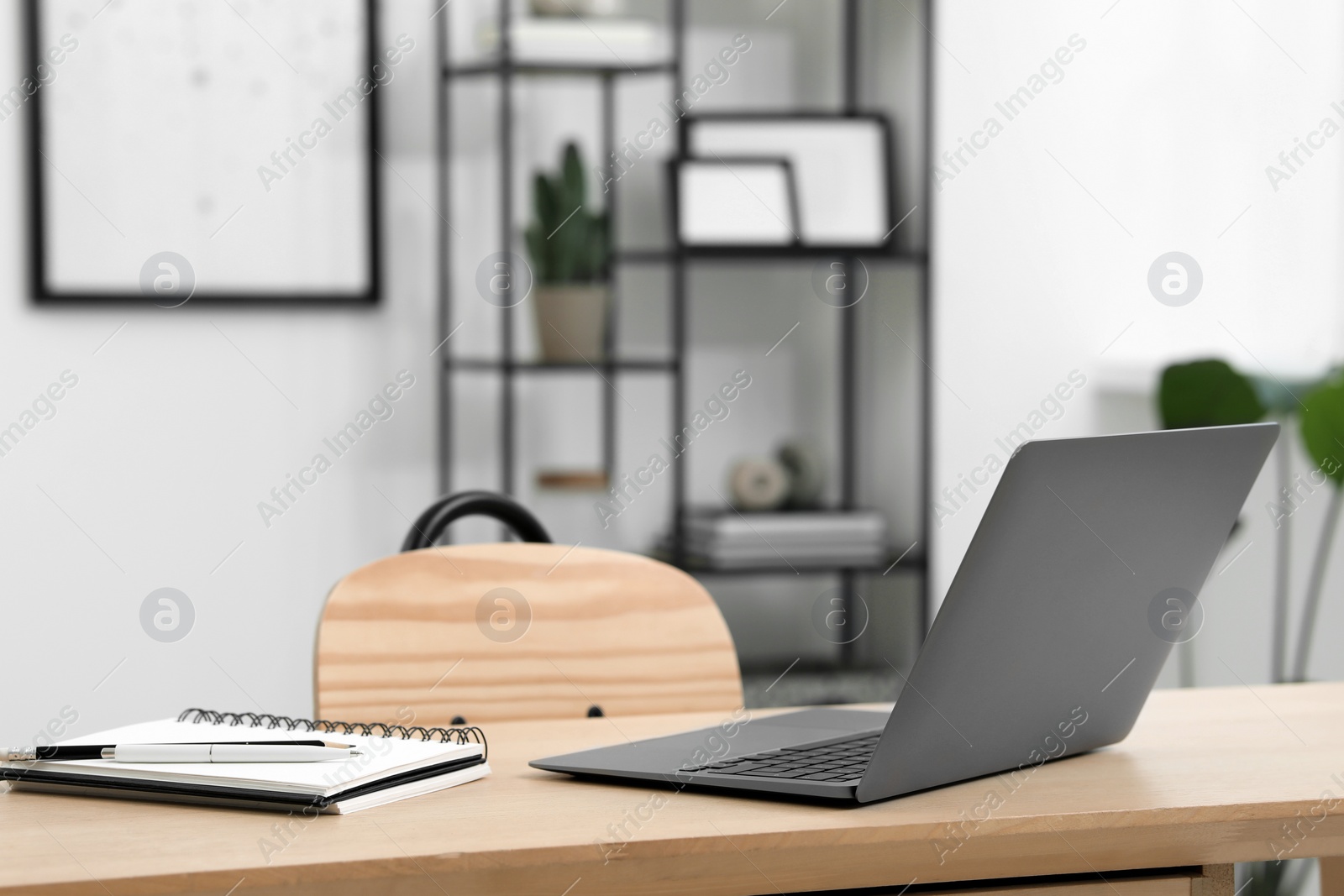 Photo of Home workspace. Laptop and stationery on wooden desk in room