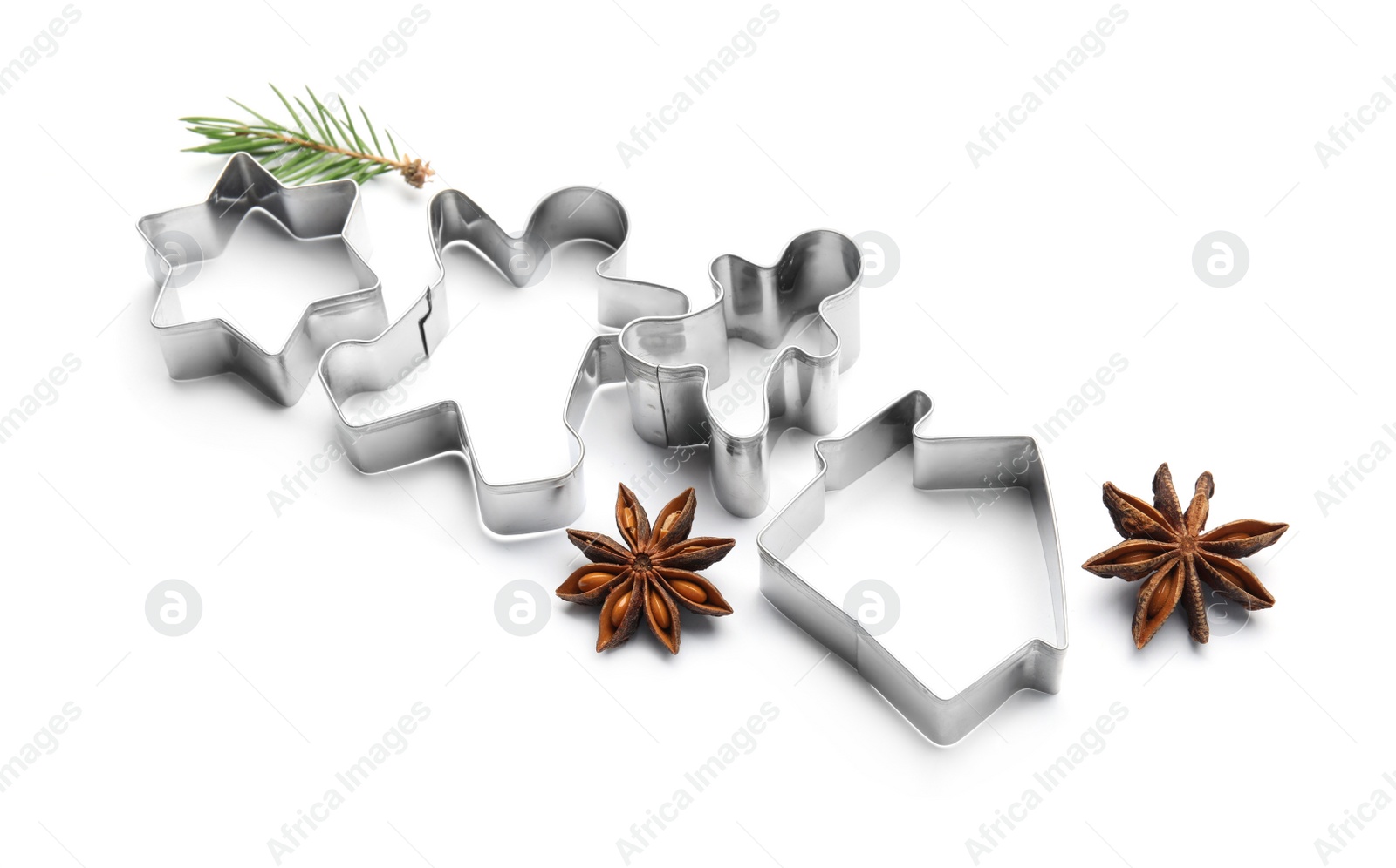Photo of Different cookie cutters, fir branch and anise stars on white background