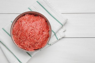 Photo of Bowl of raw fresh minced meat on white wooden table, top view. Space for text