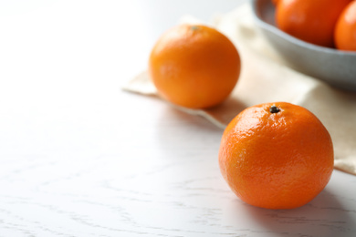 Photo of Fresh ripe tangerine on white wooden table, space for text]