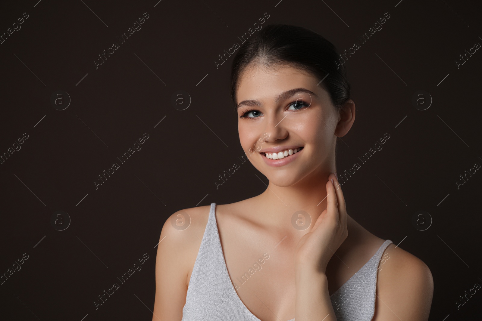 Photo of Portrait of pretty girl on brown background. Beautiful face with perfect smooth skin