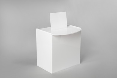 Photo of Ballot box with vote on light grey background. Election time