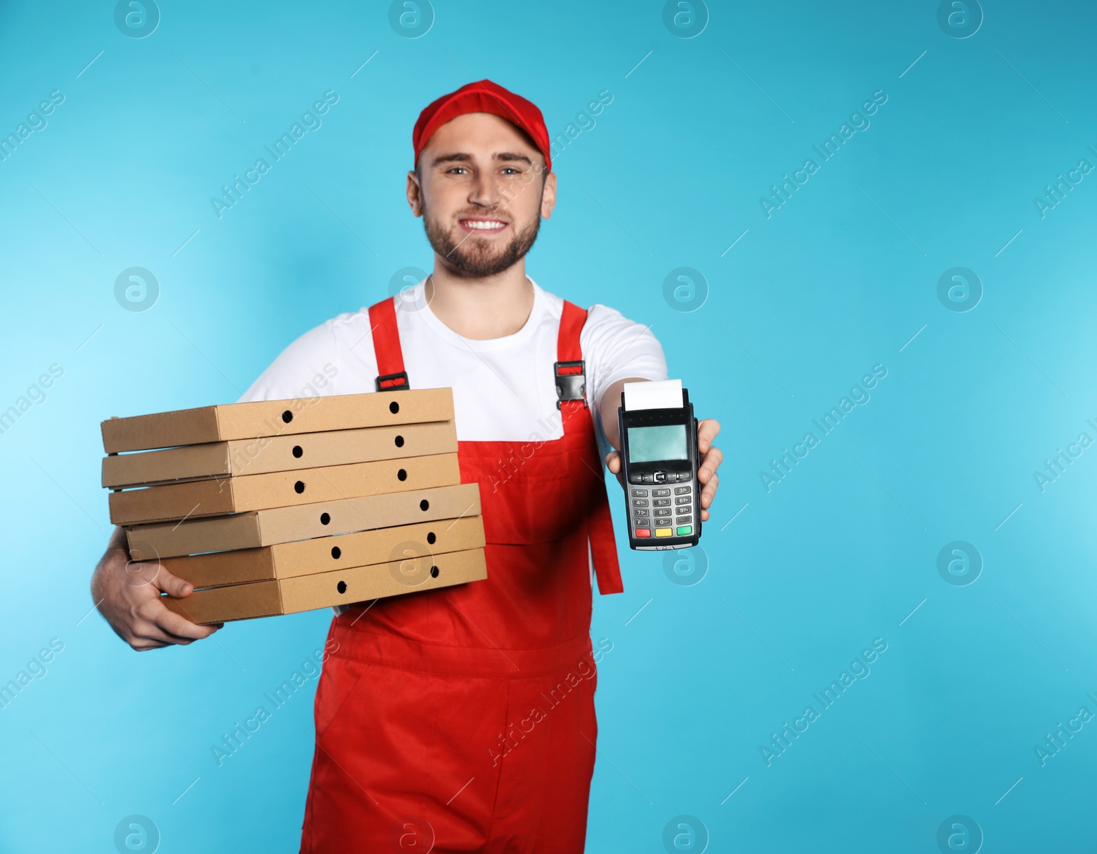 Photo of Smiling courier with pizza boxes and payment terminal on color background. Space for text