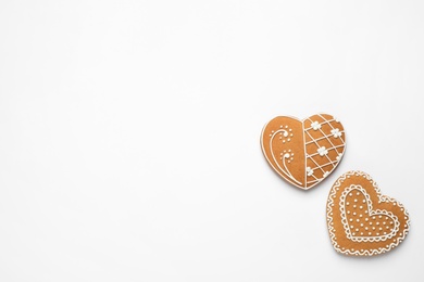 Gingerbread hearts decorated with icing on white background, flat lay. Space for text