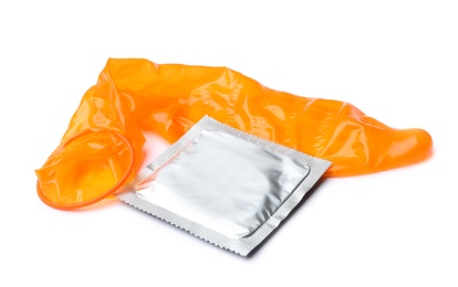 Unrolled orange condom and package on white background. Safe sex