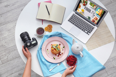 Photo of Food blogger preparing breakfast at table table, top view
