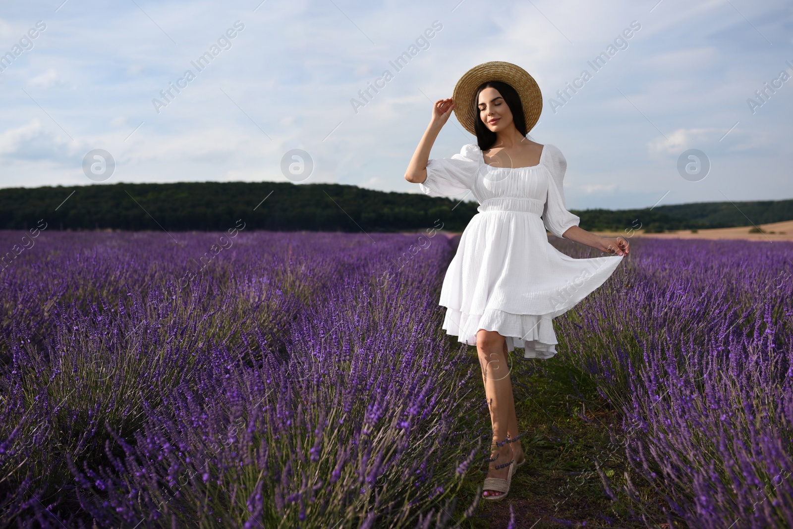 Photo of Beautiful young woman walking in lavender field