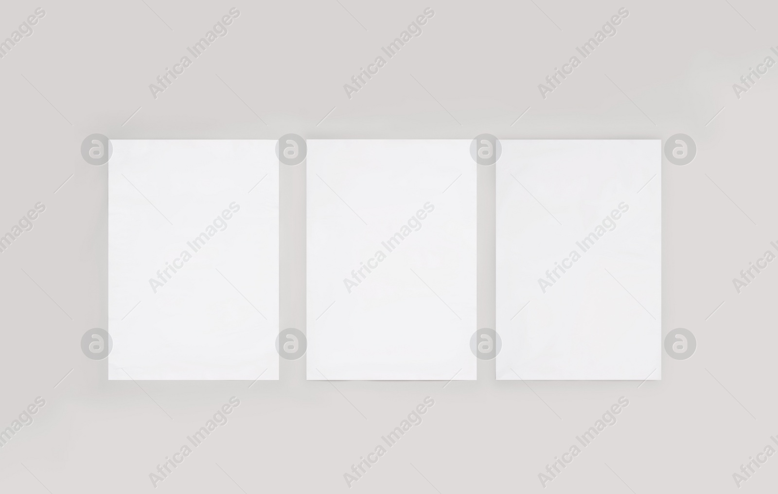 Image of Blank posters on light wall. Mockup for design 