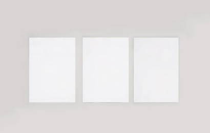 Image of Blank posters on light wall. Mockup for design 