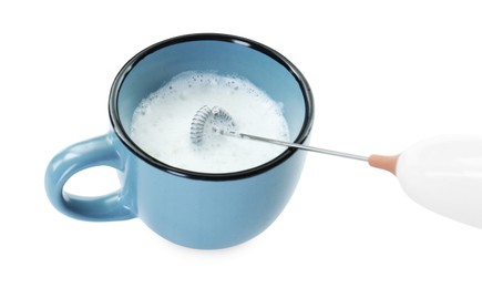 Photo of Whisking milk in cup with mini mixer (frother wand) isolated on white, closeup