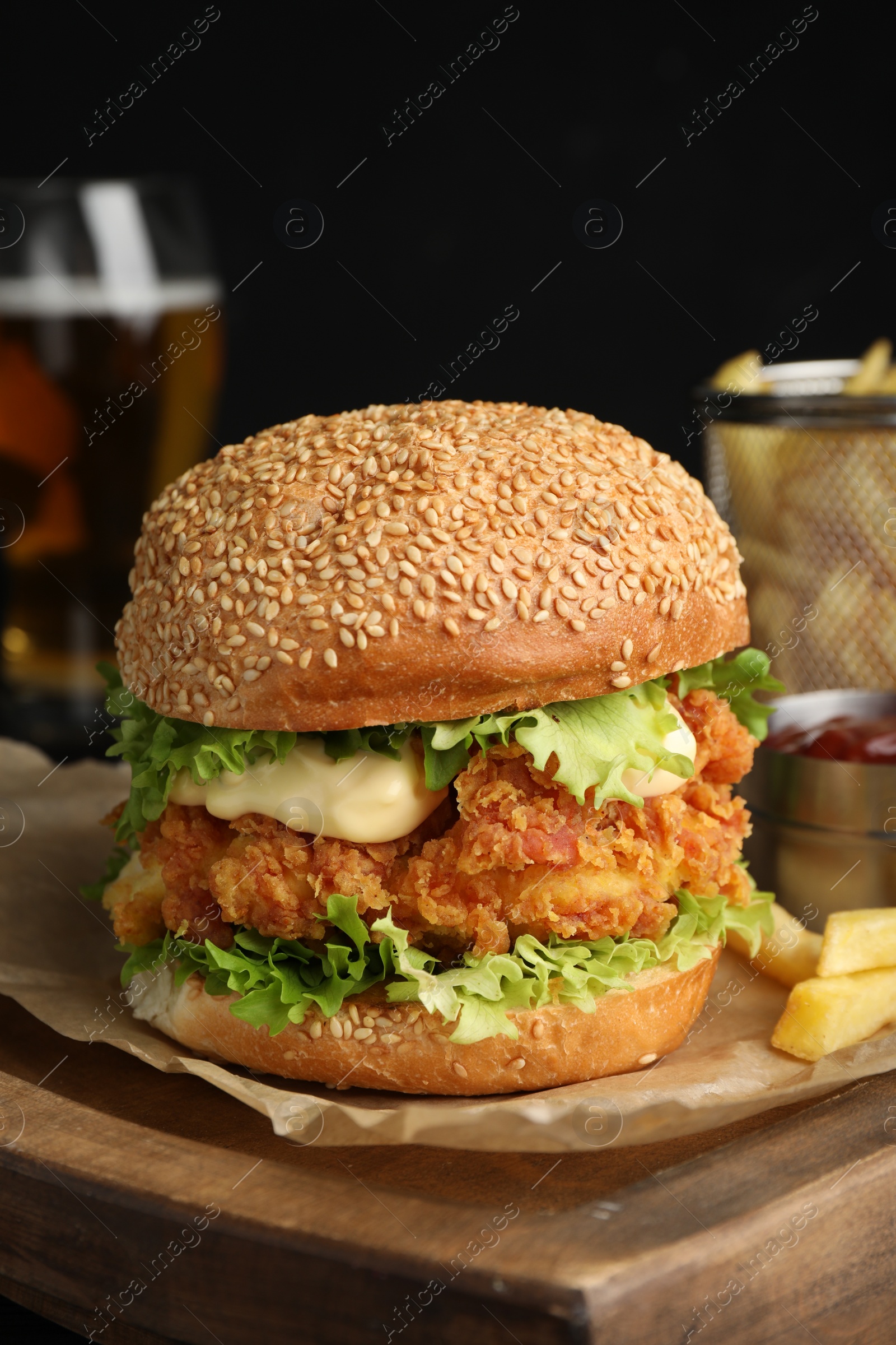 Photo of Delicious burger with crispy chicken patty on wooden table, closeup