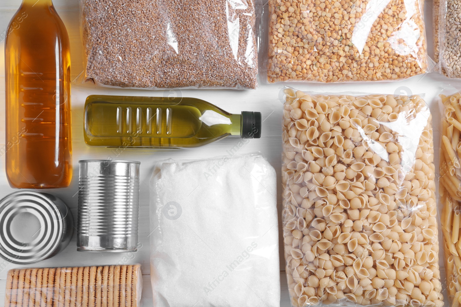 Photo of Different products on white wooden table, flat lay. Food donation