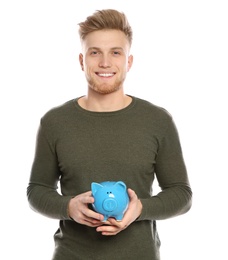 Photo of Young man with piggy bank on white background